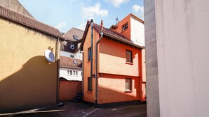 A narrow alleyway between buildings with a satellite dish and a small staircase.