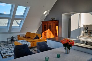 Um apartamento loft moderno com sala de jantar, cozinha e uma janela grande.