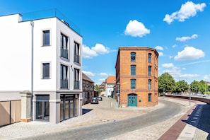 A street with a modern building and a traditional brick building.
