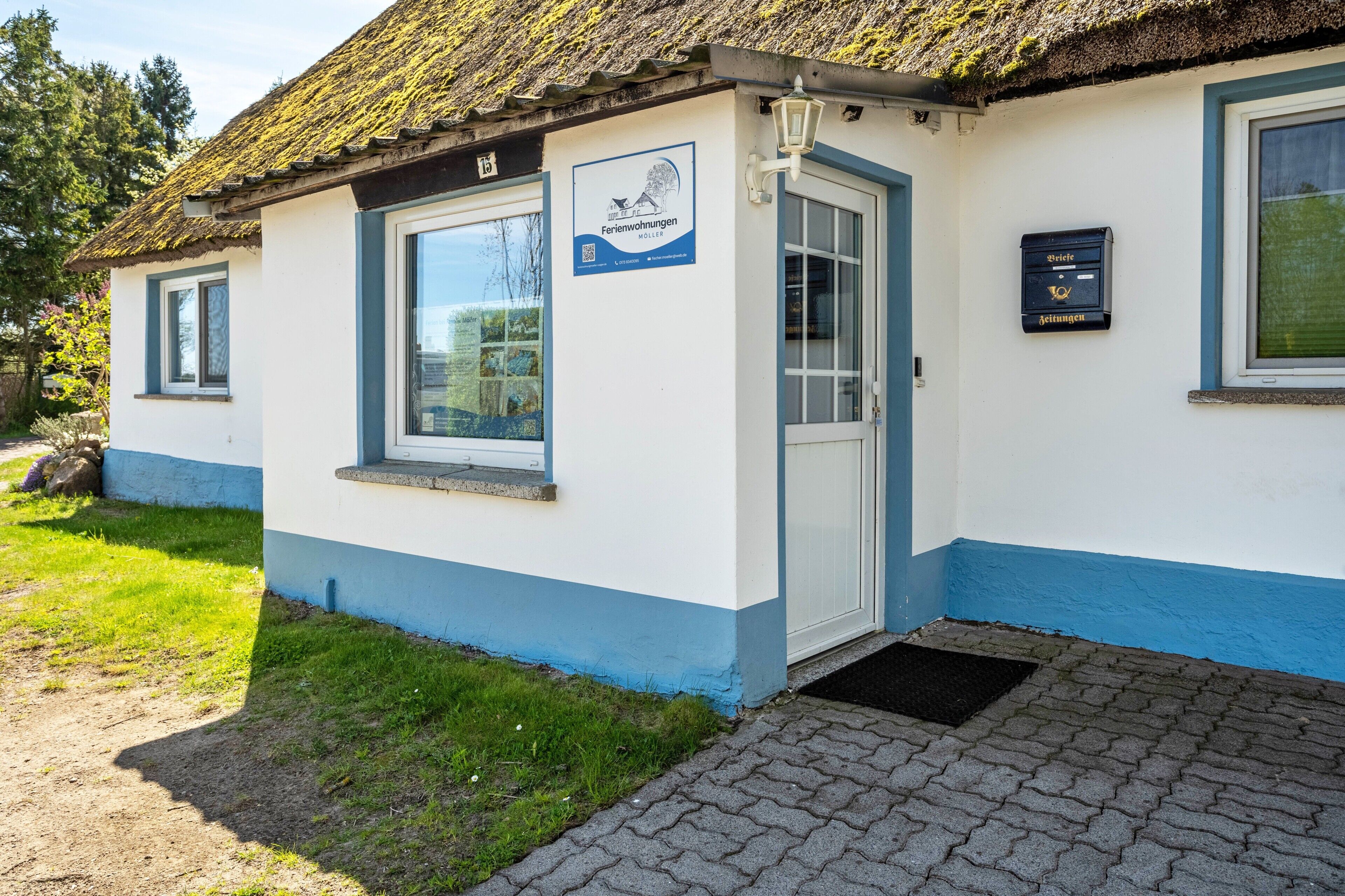 A building with a white and blue exterior, a door, and a window.