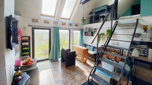 Een ruime kamer met een vide, een trap en uitzicht op de omgeving.
