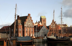 A harbor with historic buildings, a boat, and a small dock.