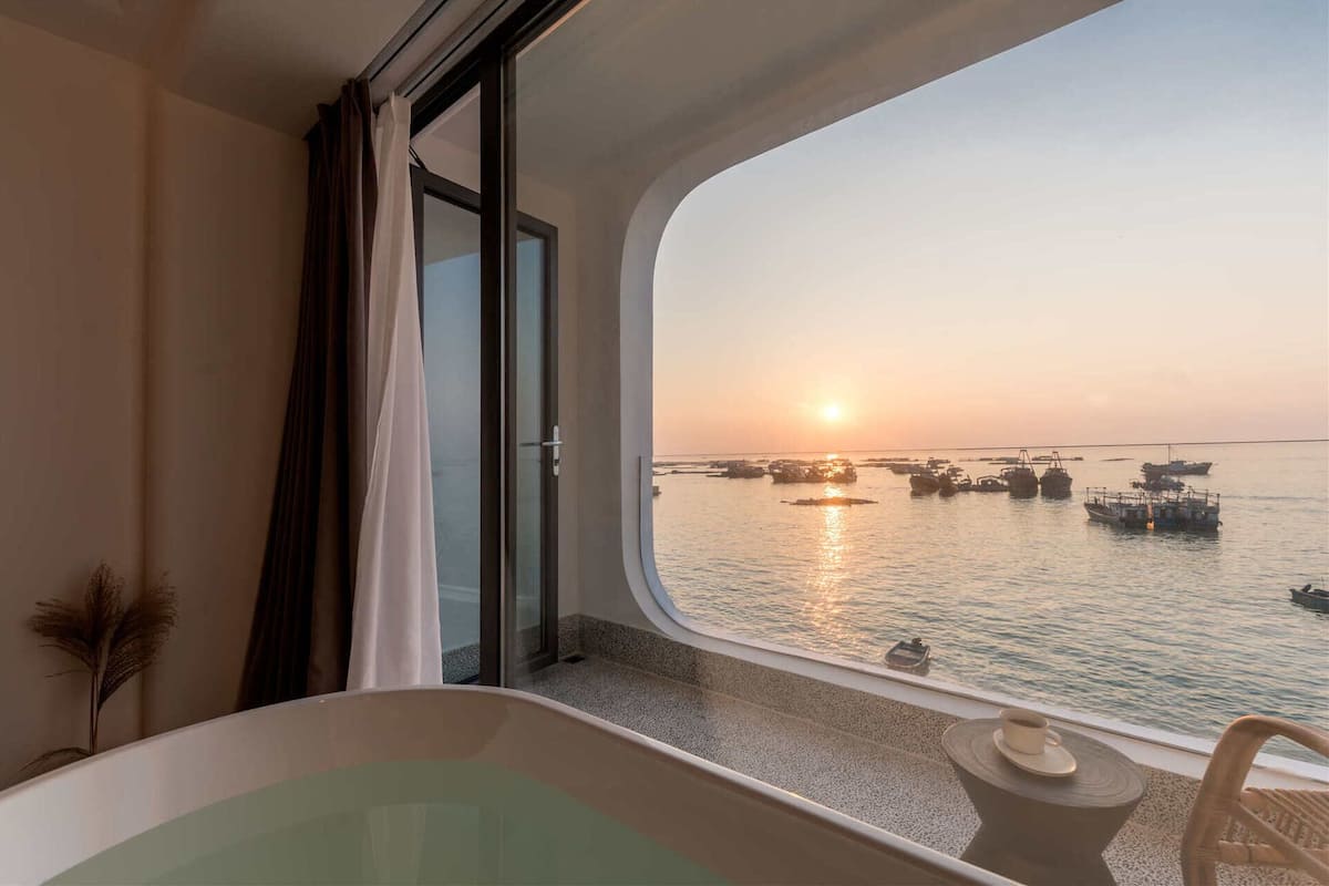 A balcony with a view of boats at sunset.