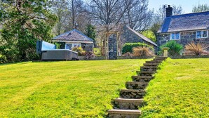 Eine Steintreppe führt zu einem Steinhaus mit einem Garten.