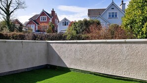 A corner of a building with a textured wall and a green lawn. - Apartment in Llanberis near Snowdonia Park (Llanberis)