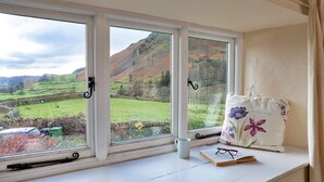 A window seat with a view of rolling hills and a stone wall. - Cottage in Grasmere near Lake & Scenic Trails (Grasmere)