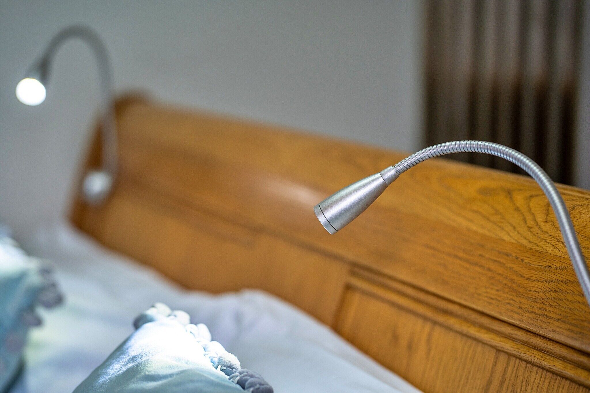 A bed with a wooden headboard and a metal headrest.