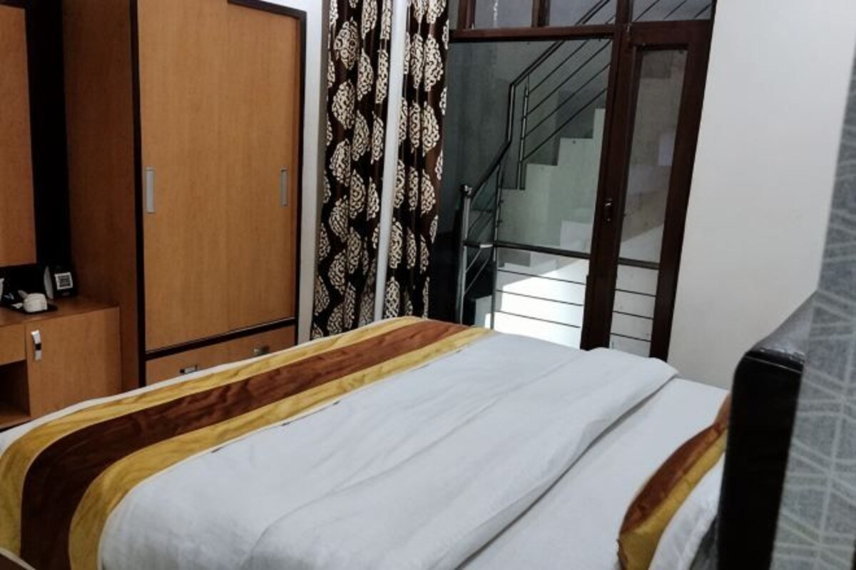 Un dormitorio con cama, armario y escalera que sube a un piso superior.