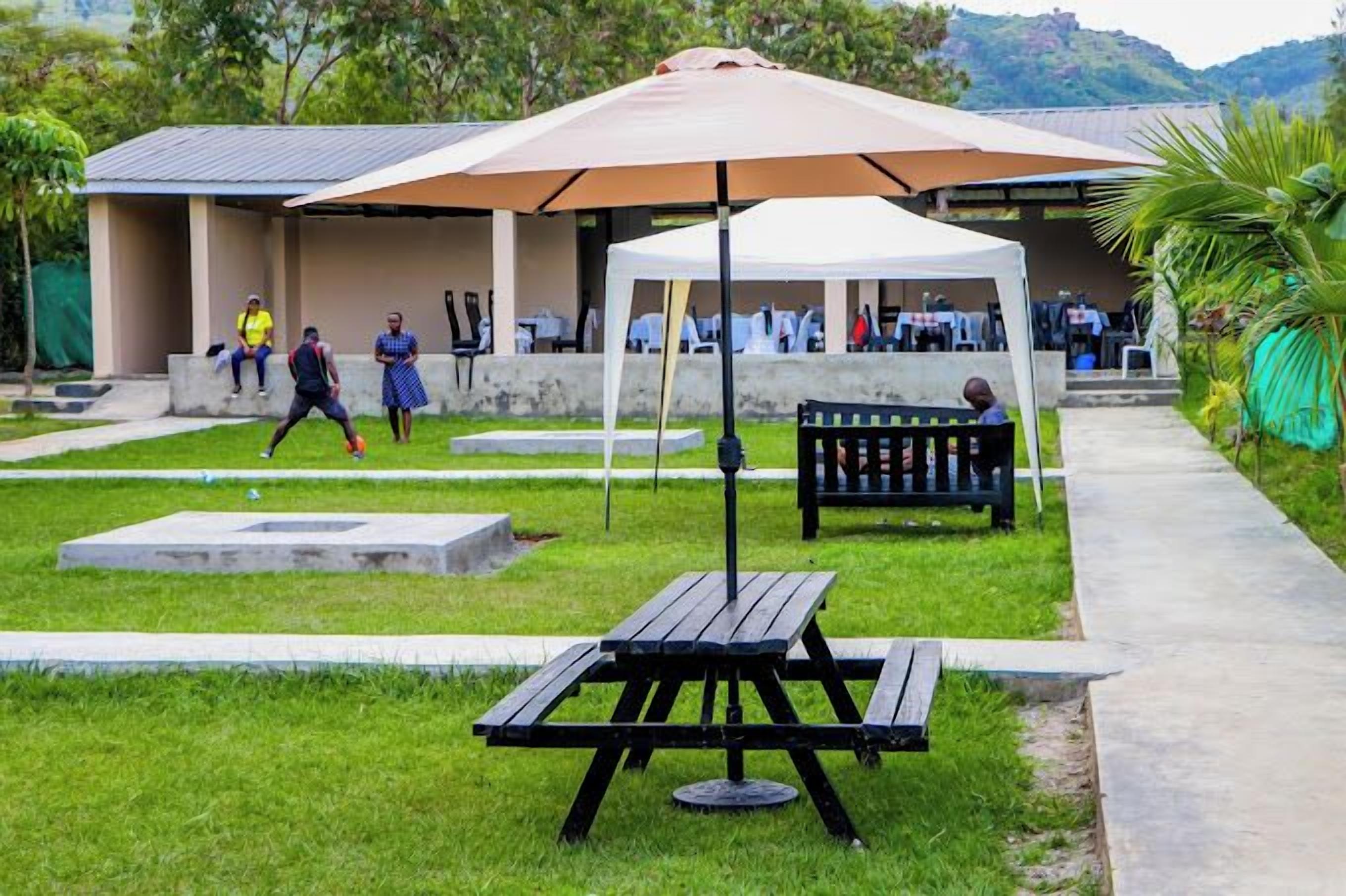 An outdoor area with a picnic table, a covered seating area, and a pathway.