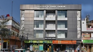 Ein Gebäude mit der Aufschrift "JAKHAR & SONS TOWER" und einem Schild für "Hotel Orchid Saffron" darunter.