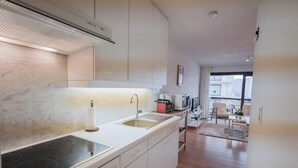 A modern kitchen with a built-in stove, a sink, and a coffee machine.