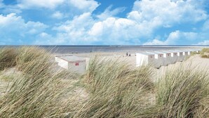 A beach with portable cabins and a clear sky.