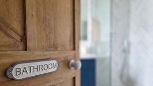 Une porte en bois avec une pancarte indiquant « salle de bain ».
