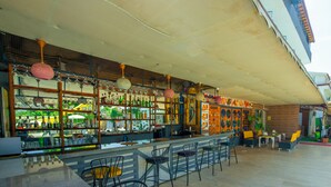 An outdoor bar area with a long counter, multiple seating options, and a variety of bottles and glasses on display. - Aliş Hotel Fethiye (Fethiye)