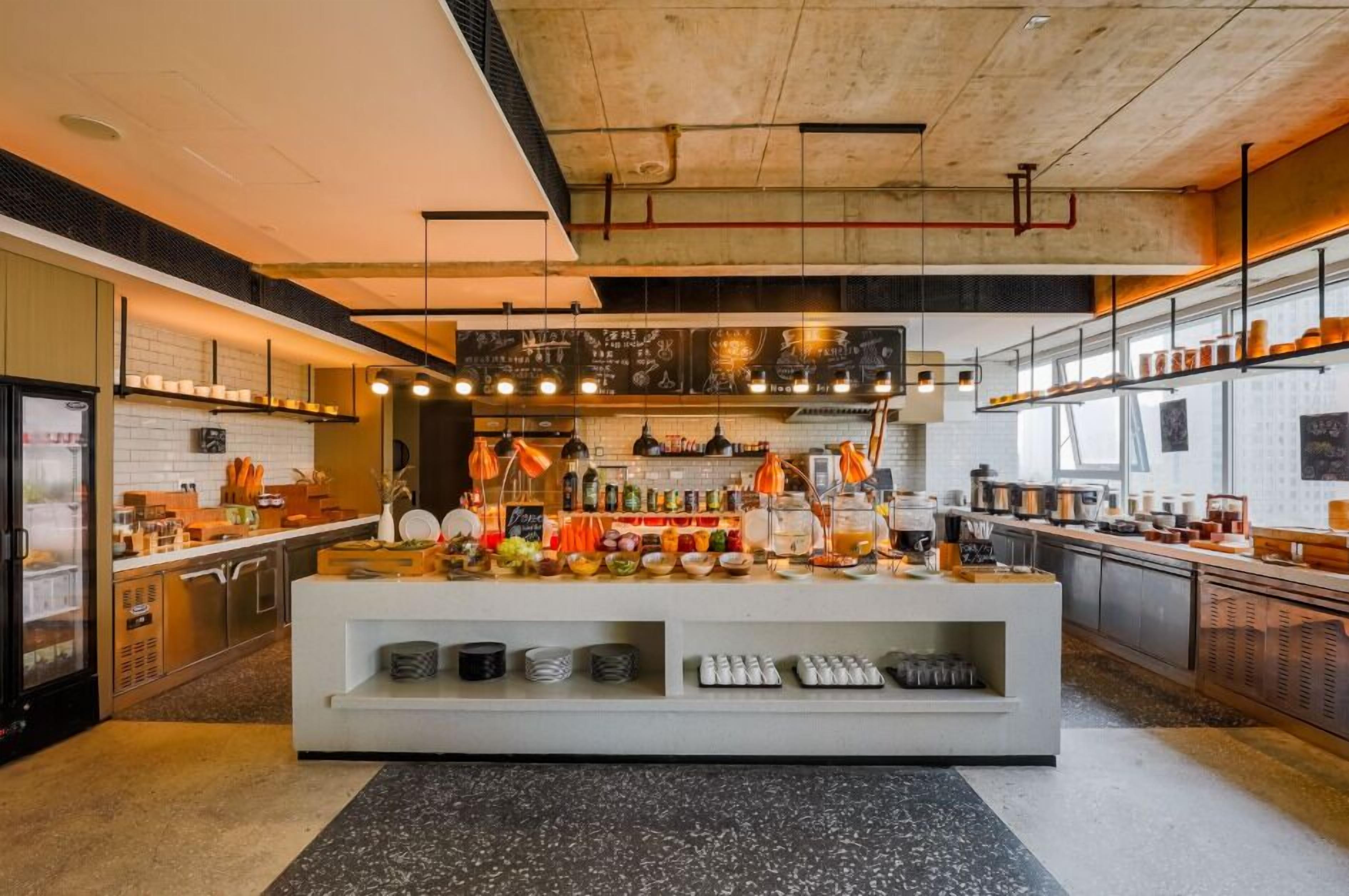 Una cocina moderna con una isla central, electrodomésticos de acero inoxidable y un menú en pizarra.
