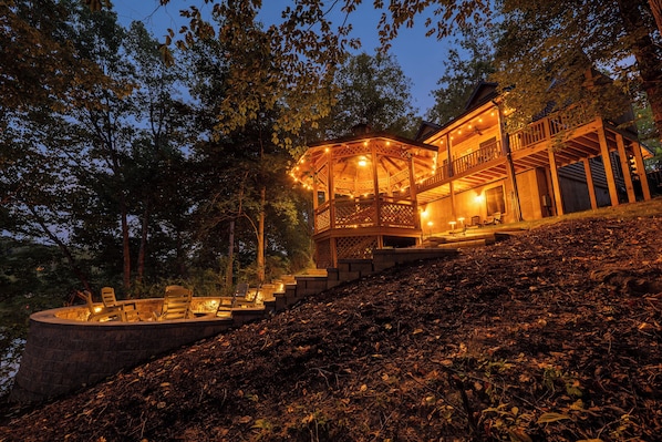 A wooden cabin with a covered deck and outdoor seating area.