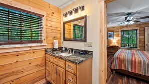 A wooden cabin-style bathroom with a sink, vanity, and a mirror. - Main Channel Lots of Water. Escape to The Getaway at Pine Haven — a spotless log cabin on Smith Mountain Lake where every bedroom has its own en-suite bath. Enjoy lake views, a stocked kitchen, fire pit, pool table, and dock access. (Union Hall)