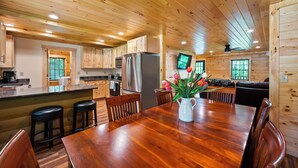 A spacious wooden cabin interior with a kitchen, dining area, and living space. - Main Channel Lots of Water. Escape to The Getaway at Pine Haven — a spotless log cabin on Smith Mountain Lake where every bedroom has its own en-suite bath. Enjoy lake views, a stocked kitchen, fire pit, pool table, and dock access. (Union Hall)