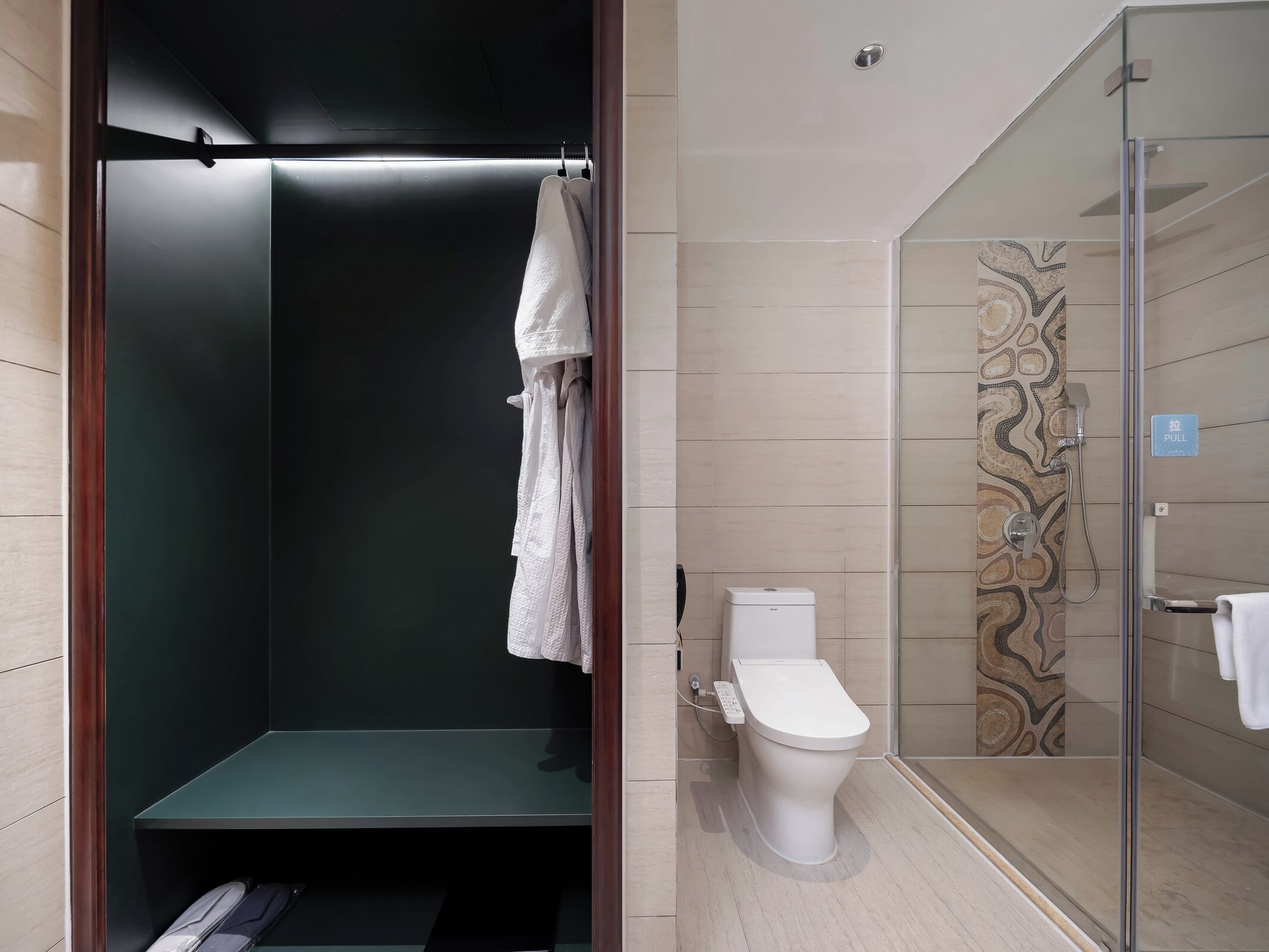 Un baño moderno con ducha, inodoro y toallero.