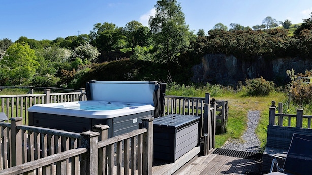 A hot tub on a wooden deck with a view of a natural landscape. - Cottage in Conwy with Hot Tub & Mountain Views (Eglwysbach)