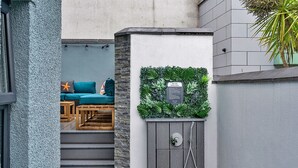 Ein moderner Außenbereich mit einer Holzbank und einem blaugrünen Sofa.