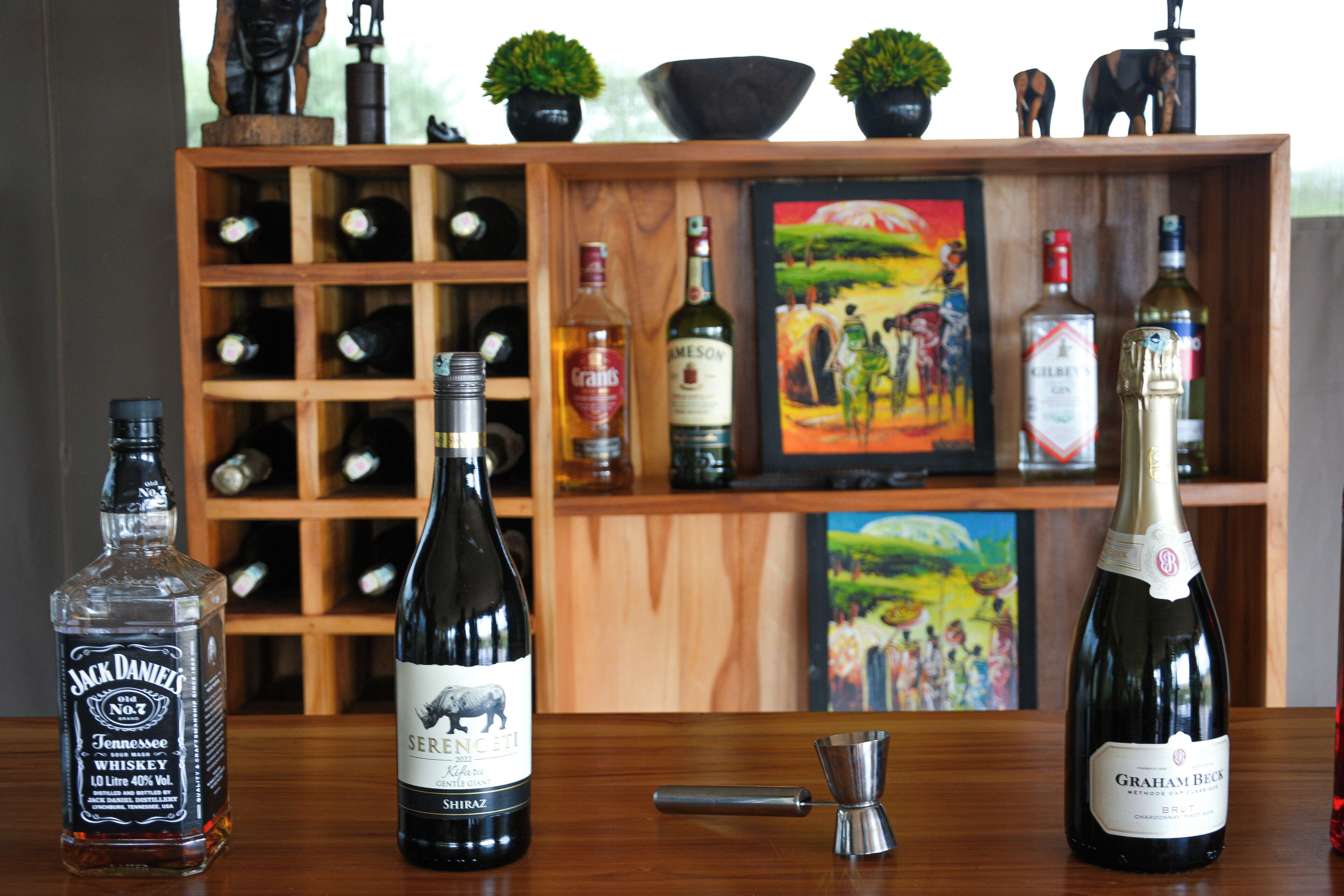 A bar area with bottles of whiskey, wine, and a cocktail shaker.