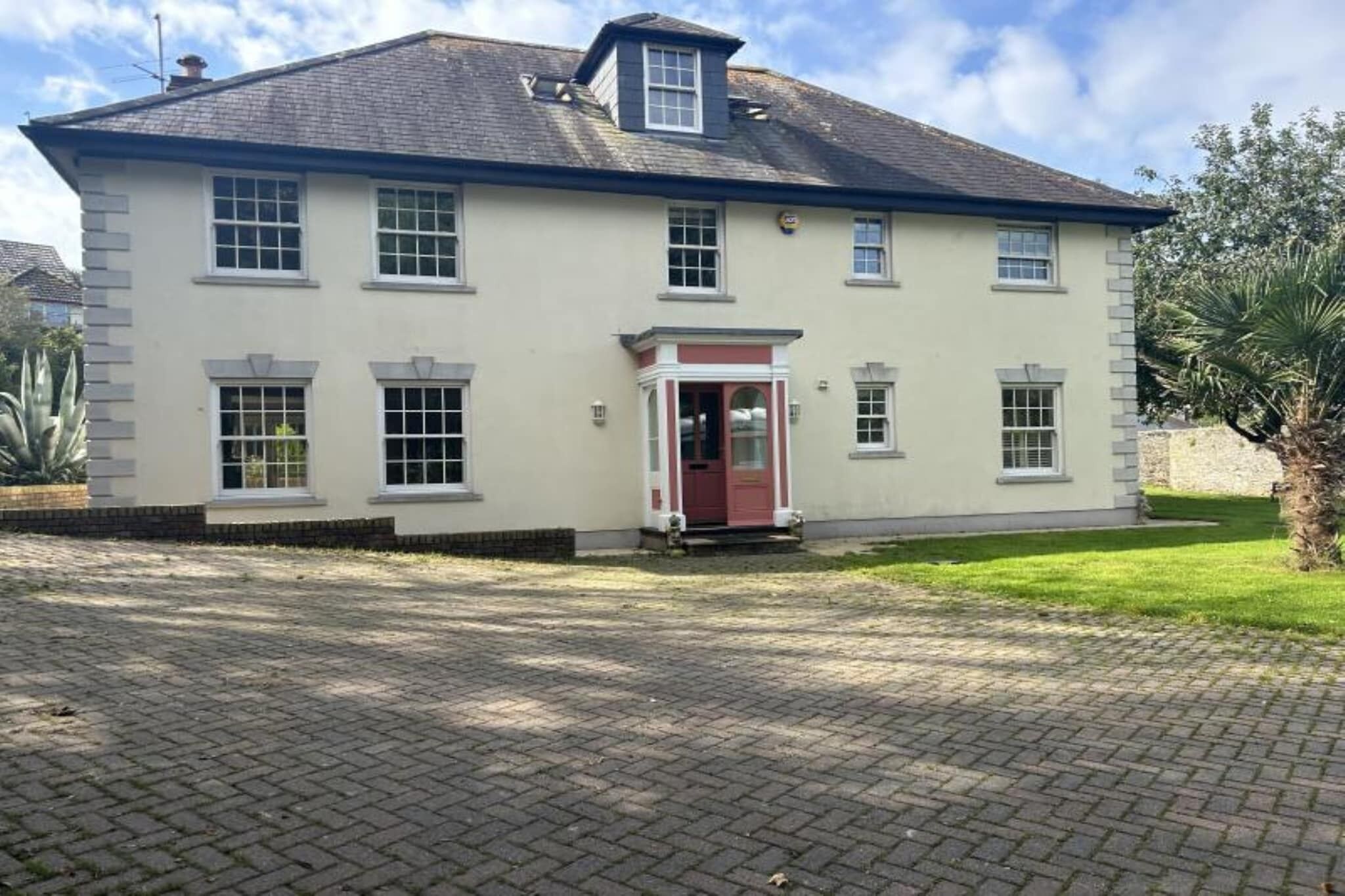 A two-story building with a red door and multiple windows.