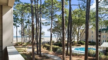 Your great view from balcony with pool.  This area is beautifully lined with oak and pine trees.