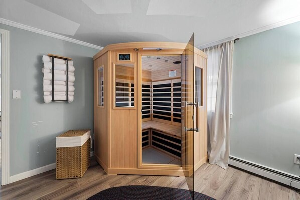En sauna med træfacade, glasdøre og kontrolpanel.