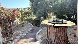 Eine Gartenpatio mit Holztisch und einem Steinweg.