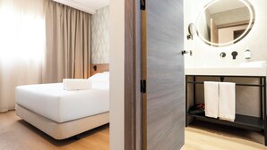 A hotel room with a bed, a bathroom with a mirror, and a door. - Alora Hotel Mérida  (Mérida)