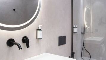 Eenpersoonskamer | Badkamer | Een douche, een haardroger, handdoeken, zeep