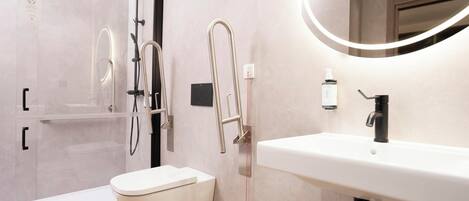 A modern bathroom with a toilet, sink, and shower.