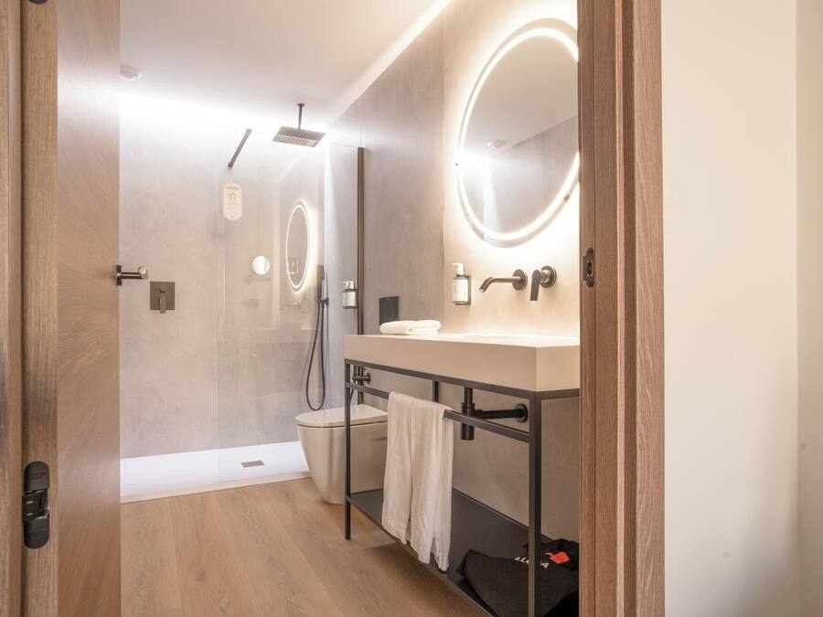 A modern bathroom with a shower, a vanity with a mirror, and a towel rack.