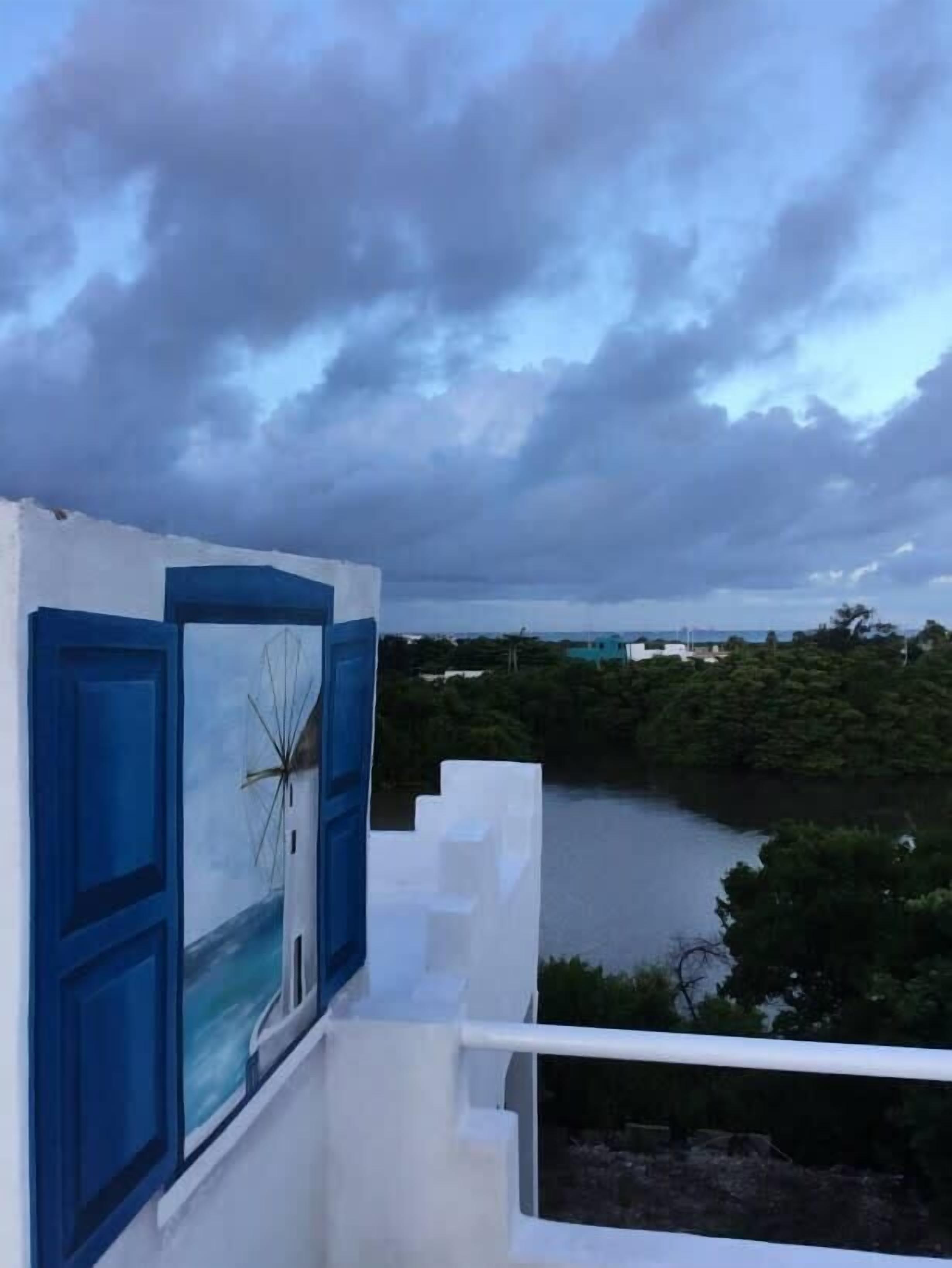 Un balcón con vista a un río y follaje.