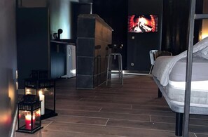 A modern hotel room with a bed, a TV, a small kitchenette, and a bar area. - l'Everest Rooms (Marseille)