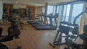 Un gimnasio con cintas de correr, elípticas y máquinas de pesas.