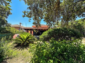 A house with a red-tiled roof, surrounded by lush greenery and a clear blue sky. - Villa with direct access to the ocean, exclusive 2,000 m² grounds, 3 bedrooms, 2 bathrooms. (Lu Impostu)