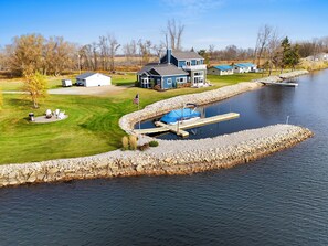 Une propriété située au bord d’un lac, dotée d’un quai, d’un petit bateau et d’une pelouse bien entretenue.