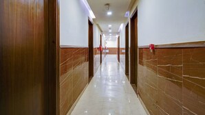 A hallway with marble walls and a shiny floor, leading to doors on both sides. - Hotel Black Rose (New Delhi)