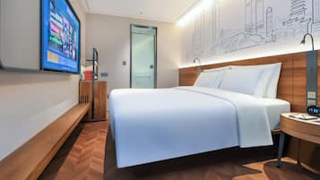 A modern hotel room with a large bed, a TV mounted on the wall, a wooden nightstand, and a cityscape mural.