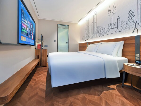 Camera d'albergo moderna con un letto grande, una TV a muro, un comodino in legno e un murale con vista sulla città.