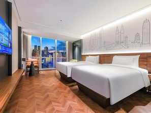 Une chambre d’hôtel avec une grande fenêtre, un lit, un bureau et une vue sur la ville.