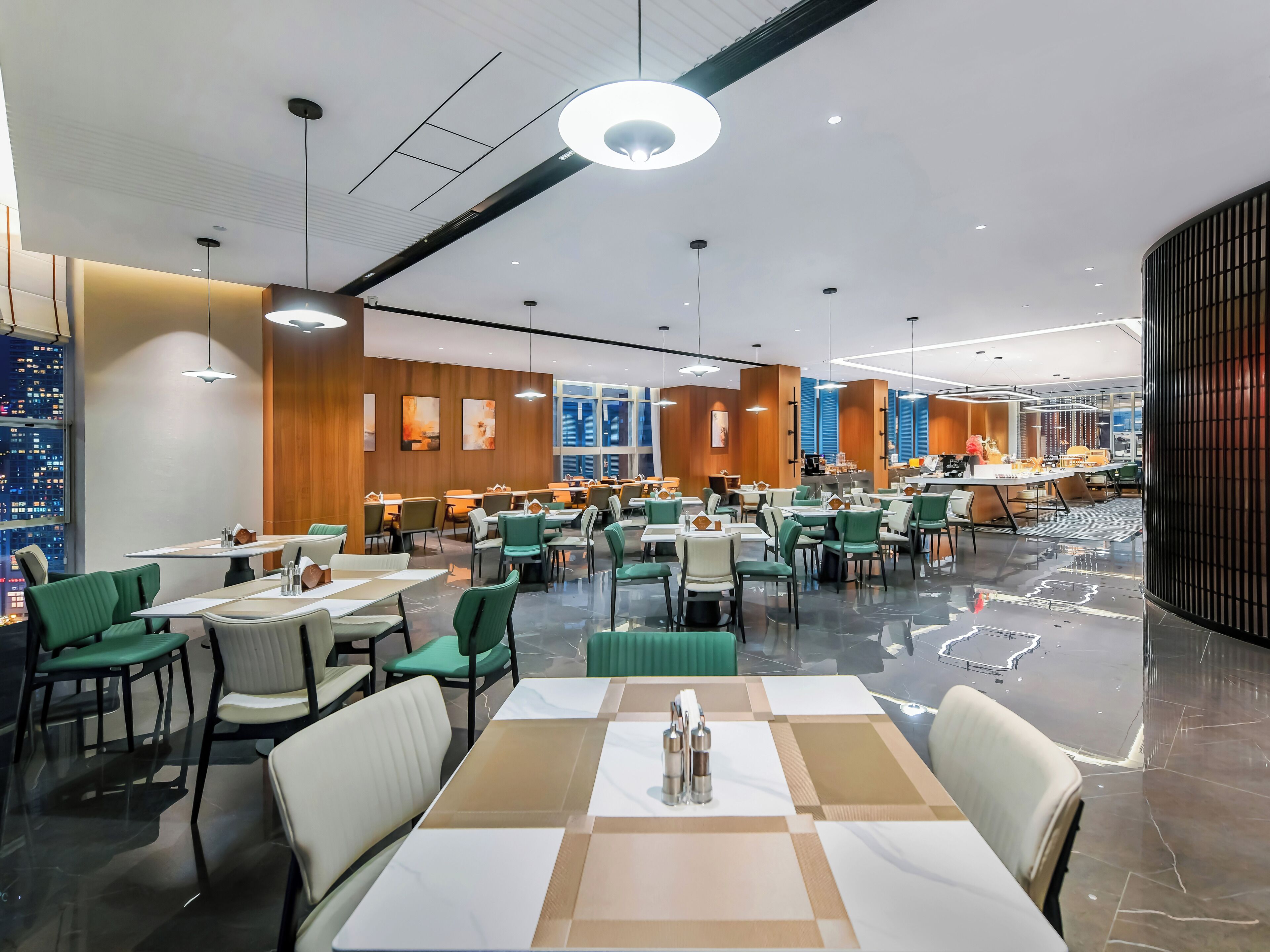 Un restaurante moderno con varias mesas y sillas, un suelo pulido y vistas a la ciudad a través de amplios ventanales.