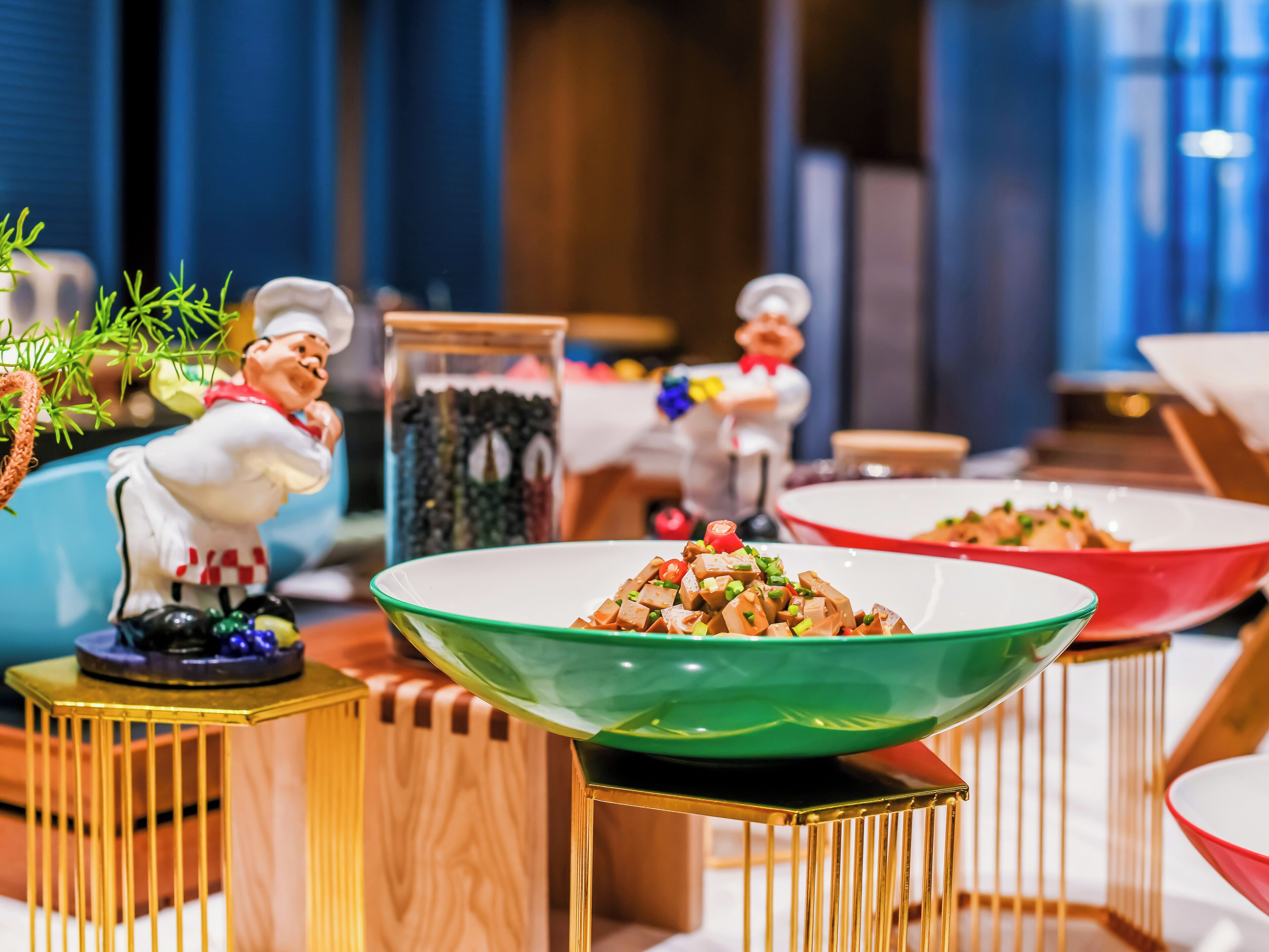 Un comedor con varias mesas, una figura decorativa y un cuenco de comida.