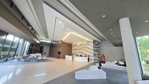 A spacious lobby with a reception desk, seating areas, and a staircase leading to upper floors. - The Grand Chaiyapruek Nimman Chiangmai (Chiang Mai)