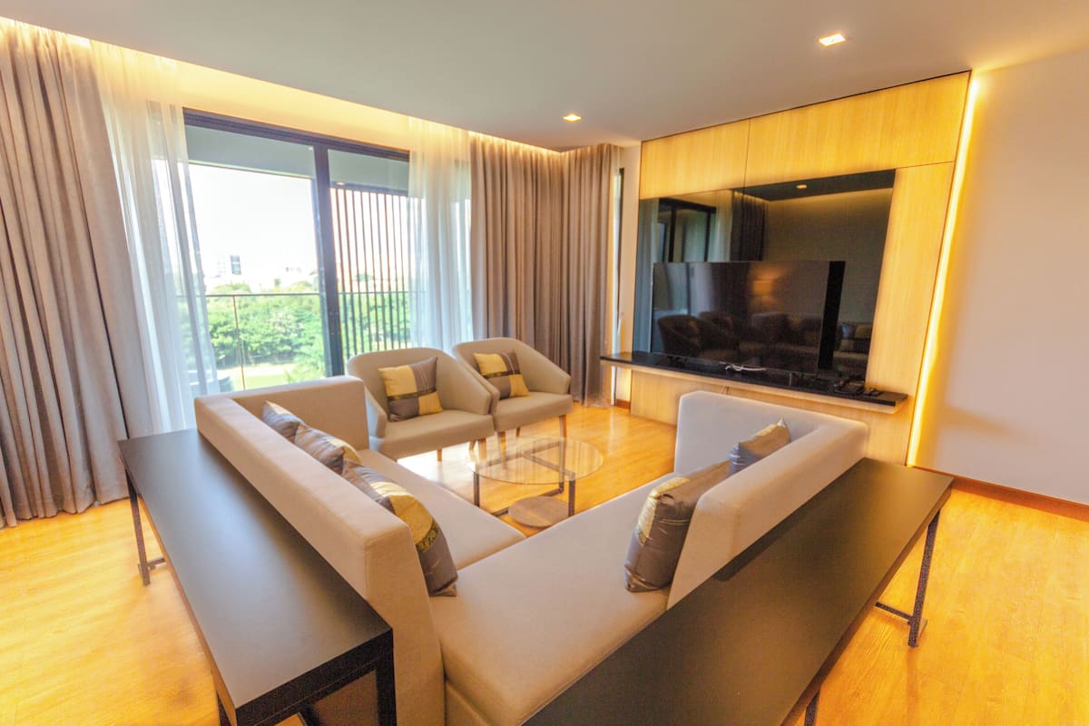 A modern living room with a sofa set, a coffee table, and a flat-screen TV.