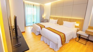 A hotel room with two beds, a TV, a bedside table, and a window with curtains. - The Grand Chaiyapruek Nimman Chiangmai (Chiang Mai)