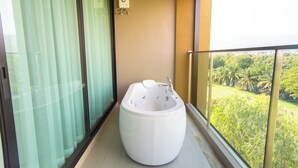 A modern bathroom with a large bathtub, a glass shower enclosure, and a view of a lush garden. - The Grand Chaiyapruek Nimman Chiangmai (Chiang Mai)