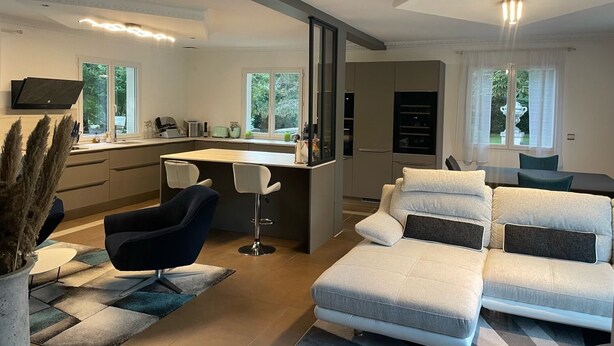 Ein modernes Wohnzimmer mit einer Couch, einem Essbereich und einer Küche.